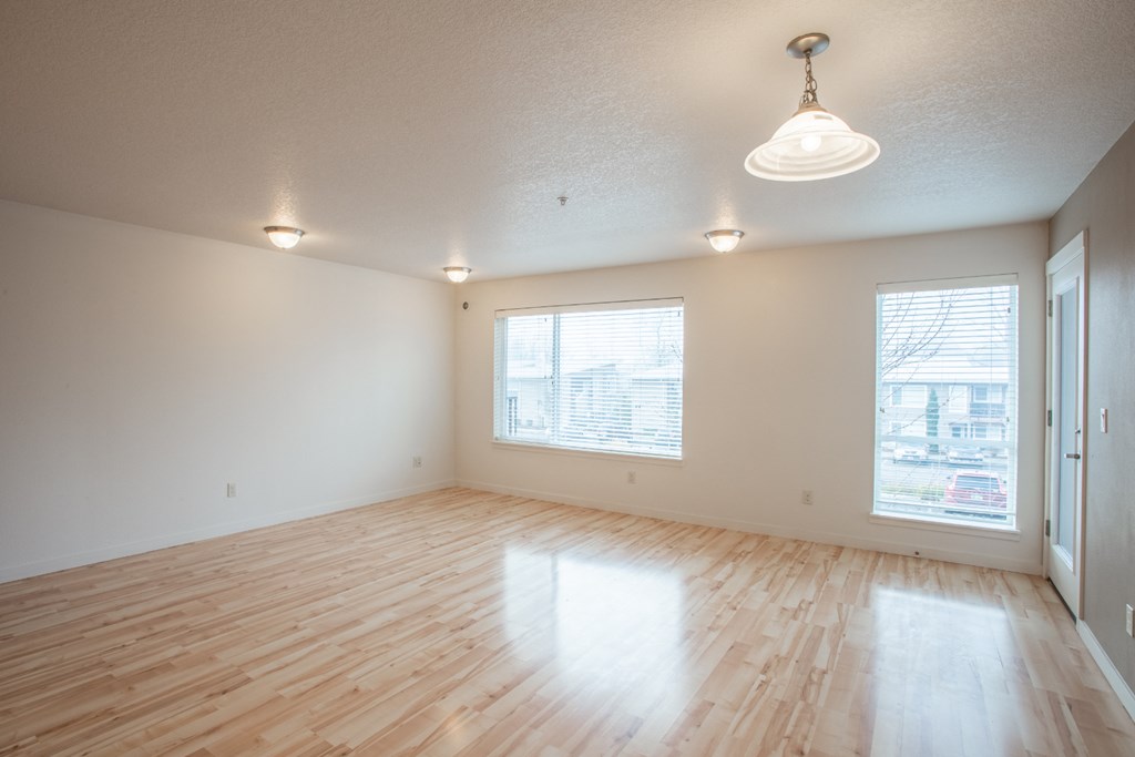 the living room of an empty house with wood floors