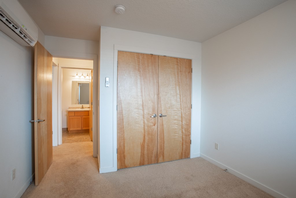 a bedroom with a closet and a door to a bathroom