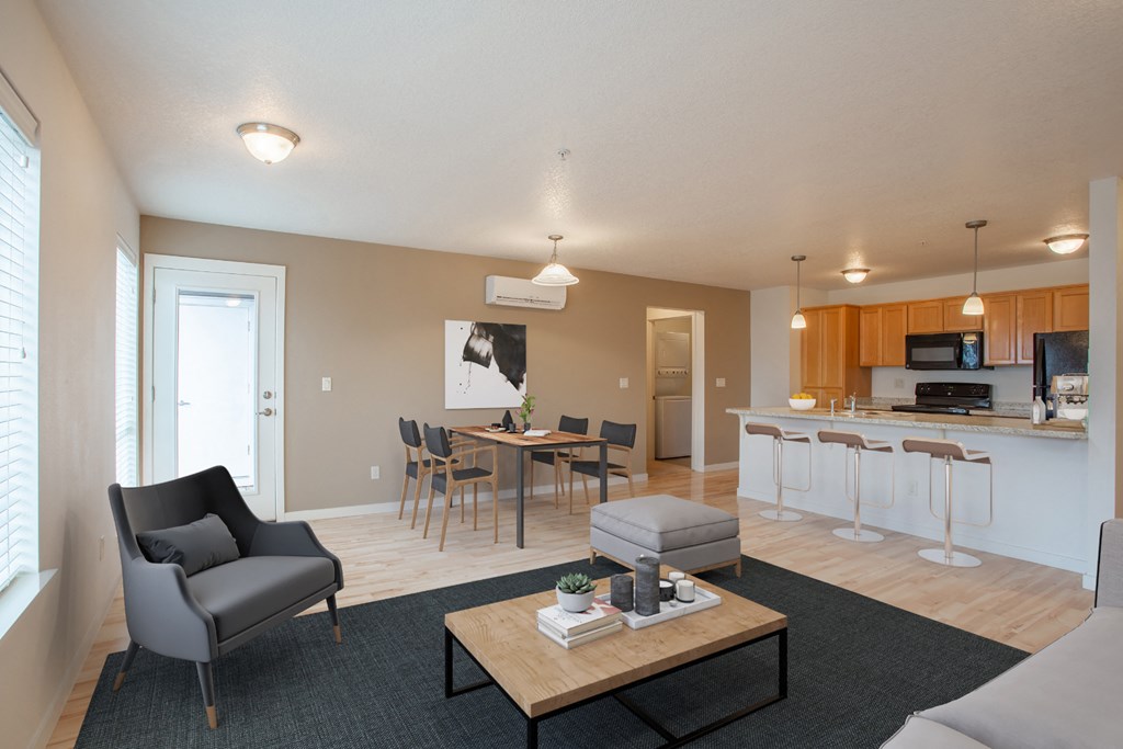 a living room with a couch and a coffee table and a kitchen with an island