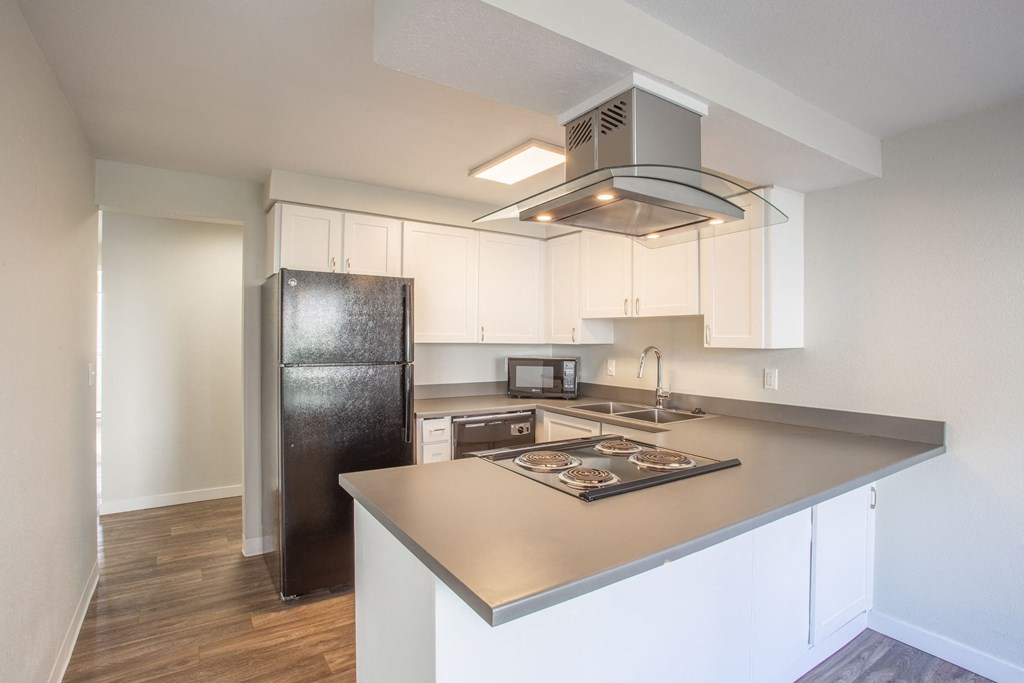 a kitchen with white cabinets and a stainless steel refrigerator