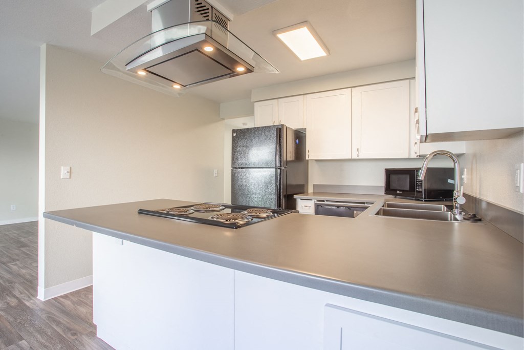 a kitchen with a large counter top and a stainless steel refrigerator