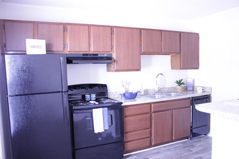 a kitchen with black appliances and wooden cabinets