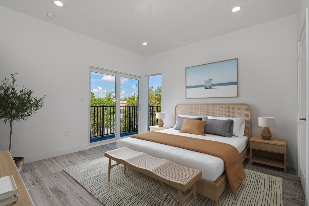 Bright, modern bedroom with balcony, rattan headboard, and beach artwork.
