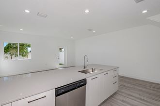 a kitchen with white cabinets and a sink and a dishwasher