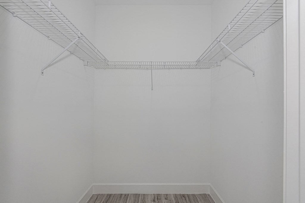 Pearl at Pompano Beach Townhomes in Pompano Beach, FL Empty walk-in closet with white wire shelving and gray wood-look flooring.