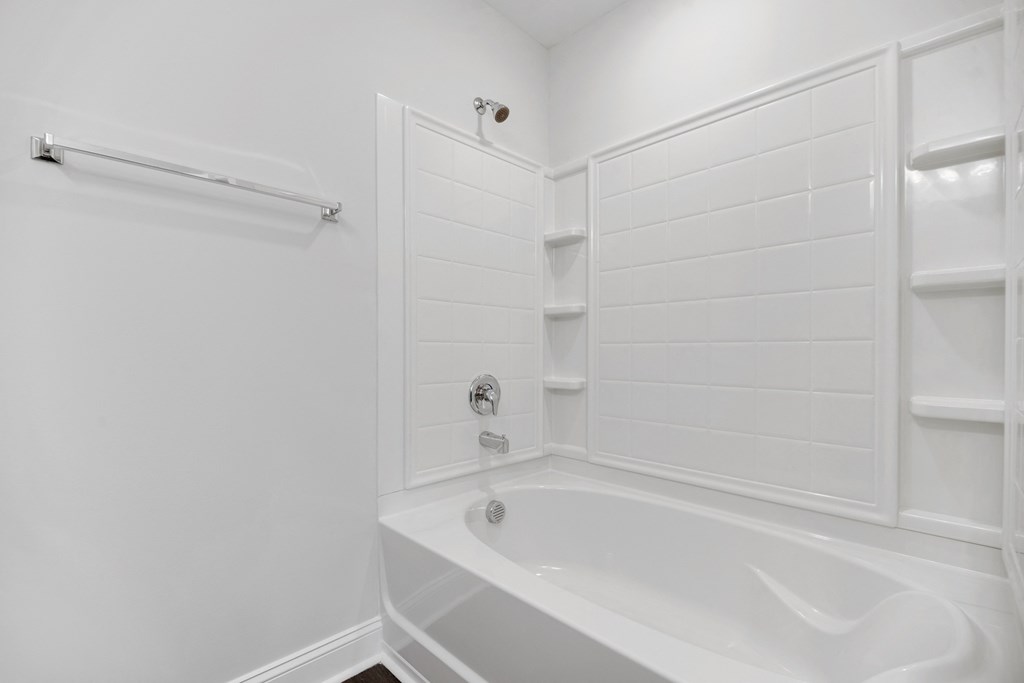 a white bathroom with a white tub and a shower
