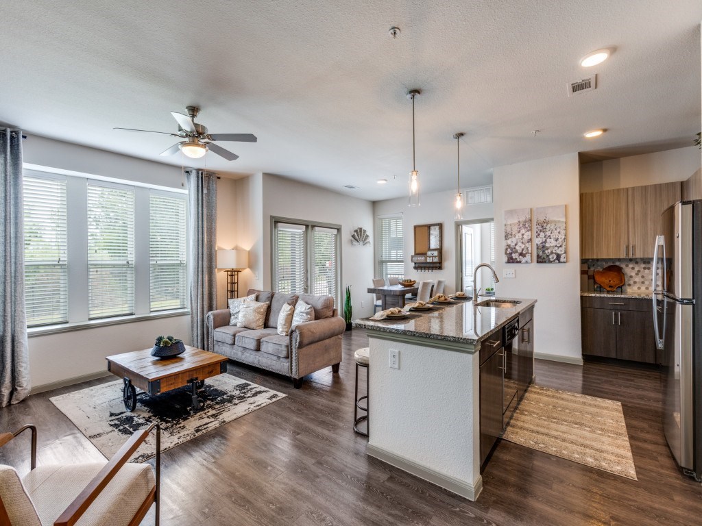 A modern kitchen with a white island and stainless steel appliances.