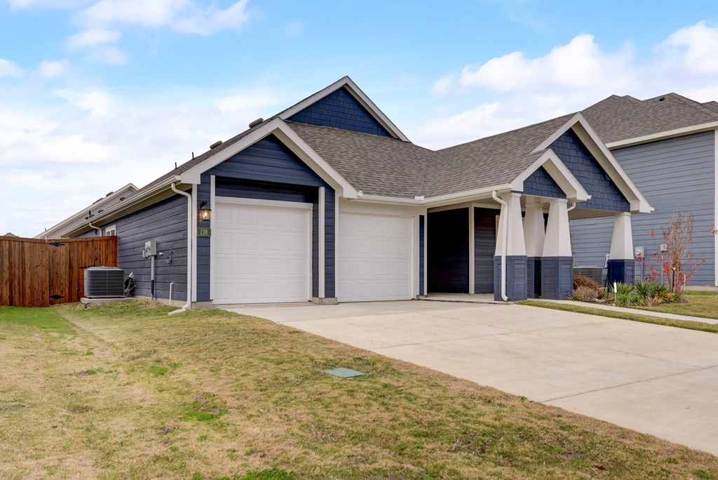 a blue house with a driveway and a garage door