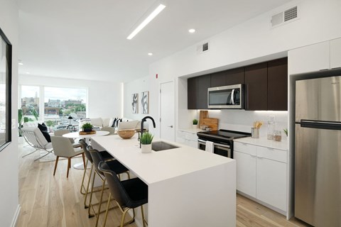 A modern kitchen with a white island and stainless steel appliances.