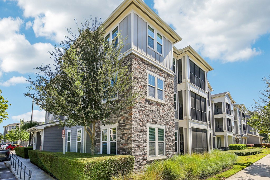 Multi-story residential buildings with attached garages and clean walkways at Lotus at Starkey Ranch in Odessa, Florida.