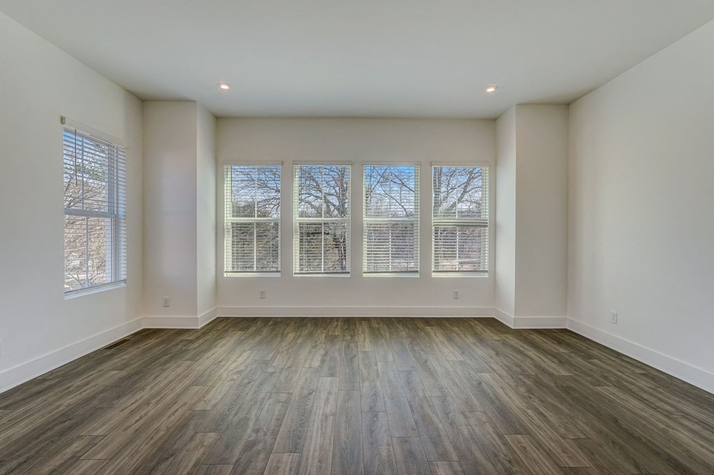 an empty living room with wood floors and windows