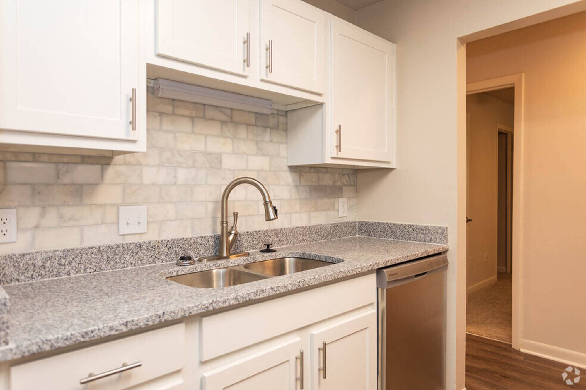 a kitchen with white cabinets and a sink