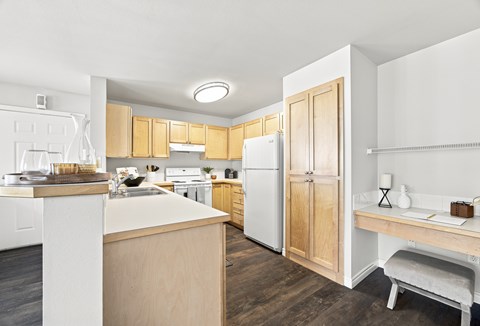 A kitchen with white appliances and wooden cabinets.