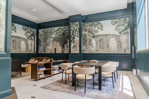 a dining room with large windows and a table and chairs