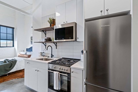 a kitchen with a stainless steel refrigerator and a sink