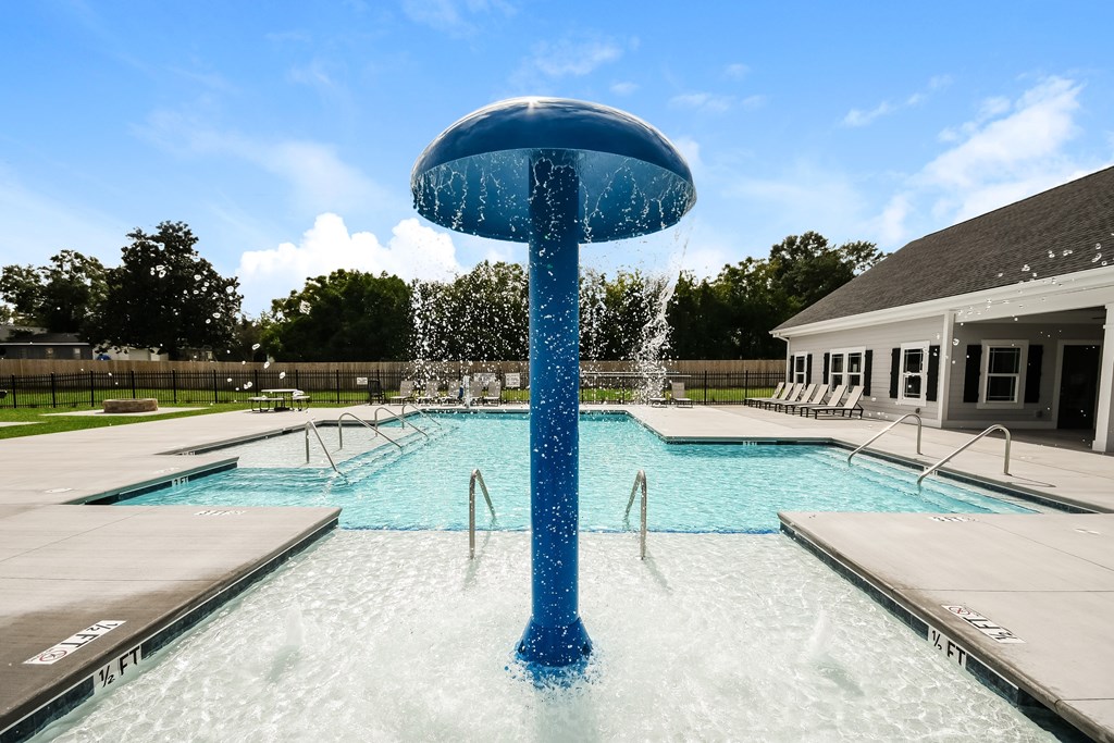 A blue water fountain in the middle of a pool.