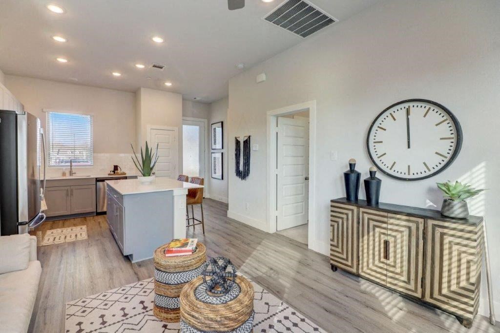 a living room and kitchen with a large clock on the wall