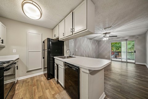 A kitchen with black appliances and white cabinets.