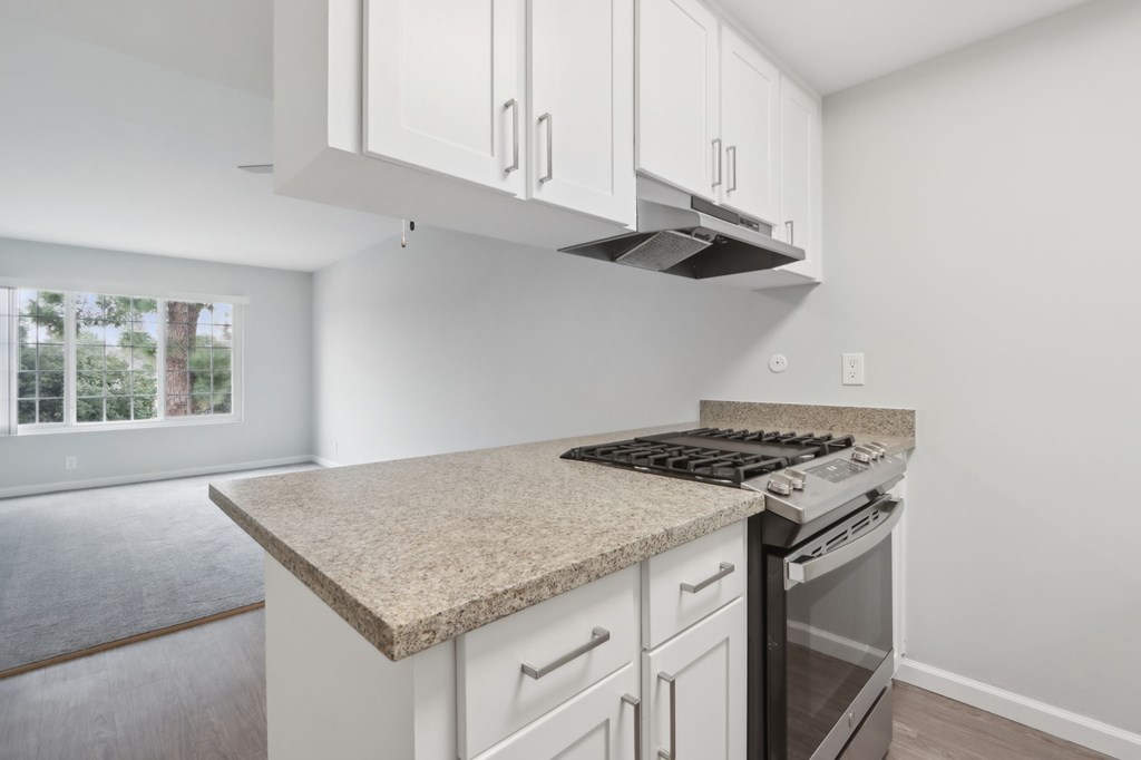 A kitchen with a granite countertop and white cabinets.