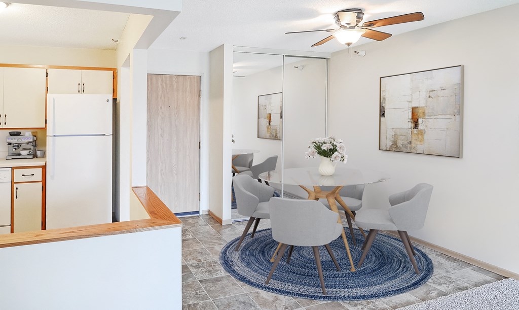 A modern dining room with a white table and chairs.