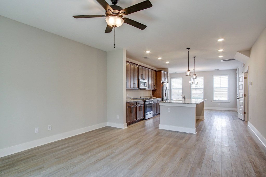 an open kitchen and living room with a ceiling fan