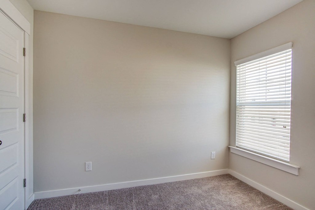 an empty room with a window and a door