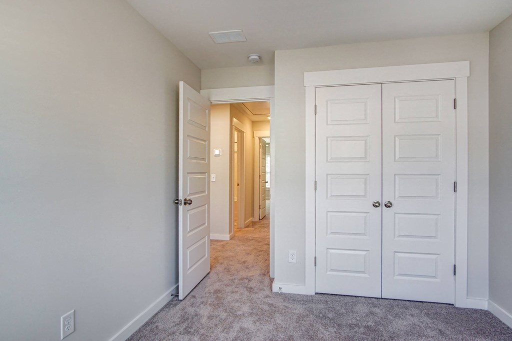 a bedroom with two closets and a hallway leading to a closet