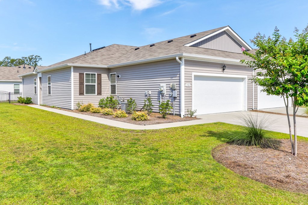 a blue house with a garage and a lawn