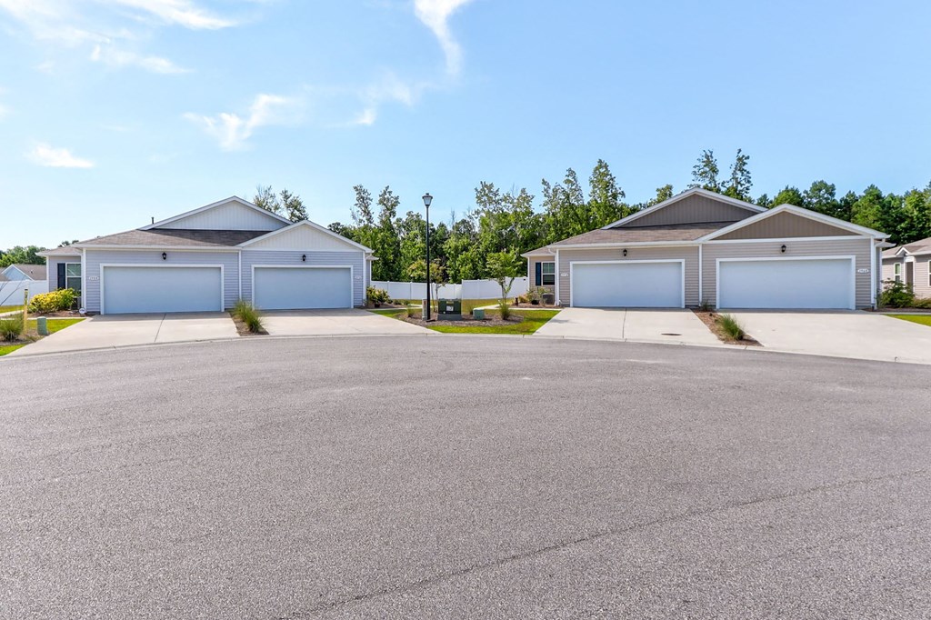 a house with two garages and a street in front of it