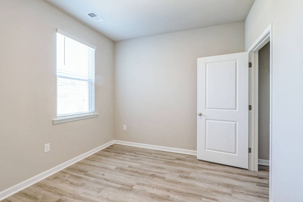 an empty room with a white door and a window
