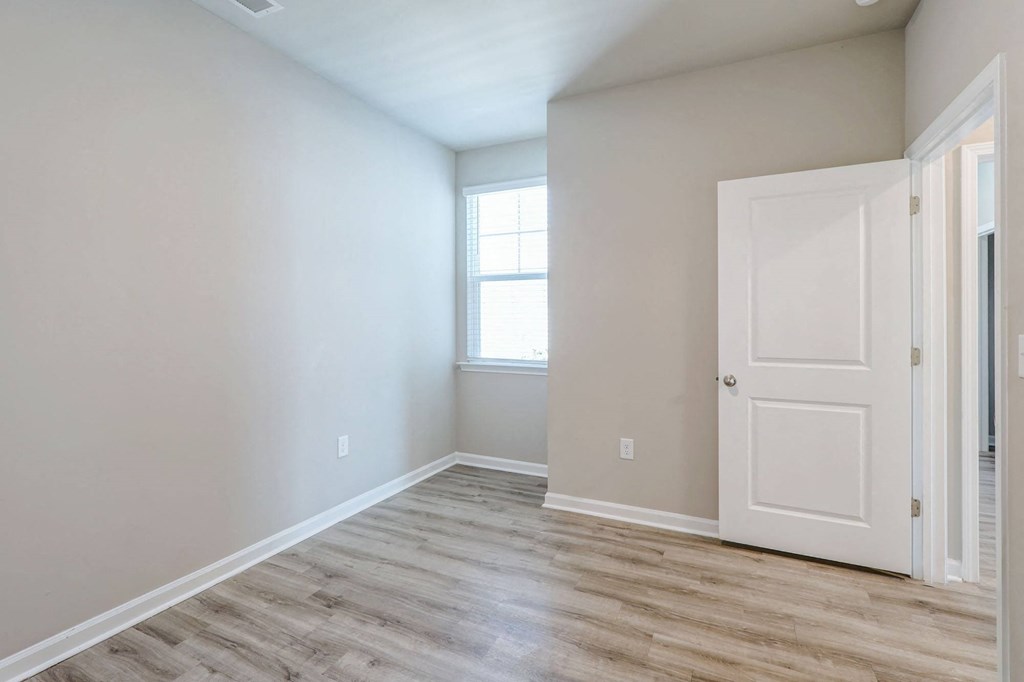 an empty room with a white door and a window