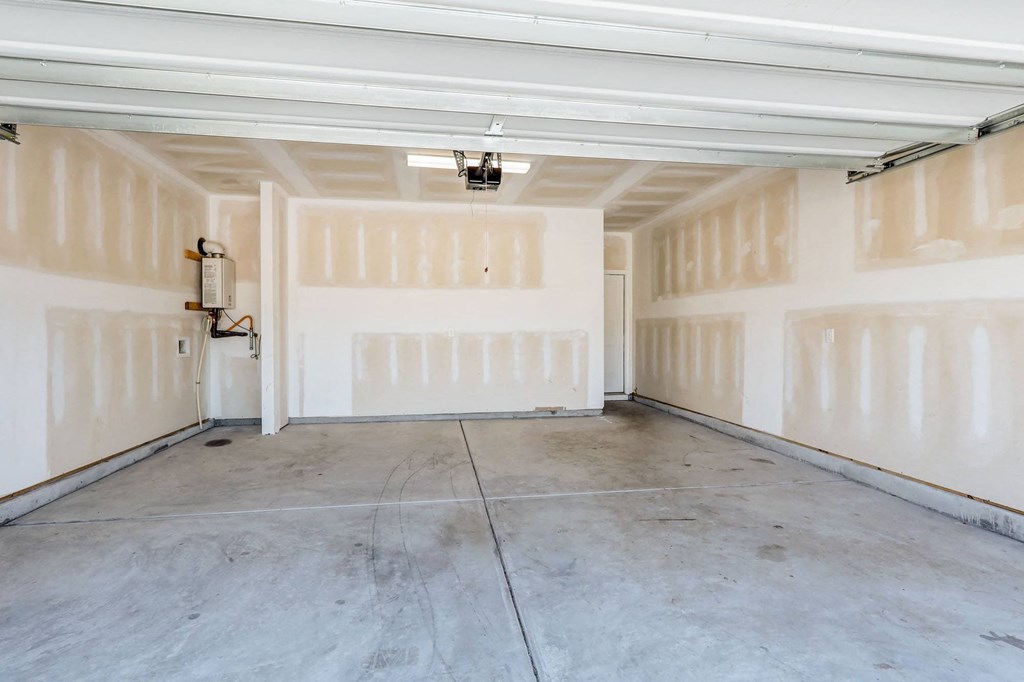 the inside of a garage with white walls and a concrete floor