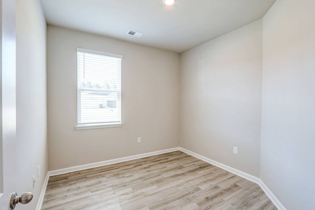 an empty room with white walls and a window