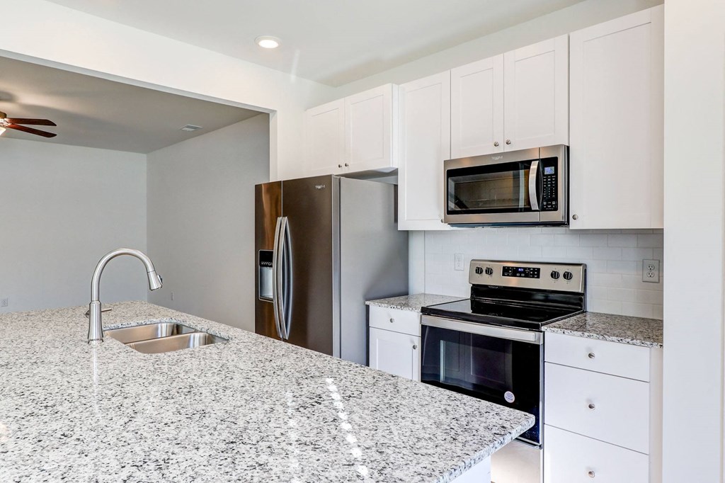 a kitchen with granite counter tops and stainless steel appliances