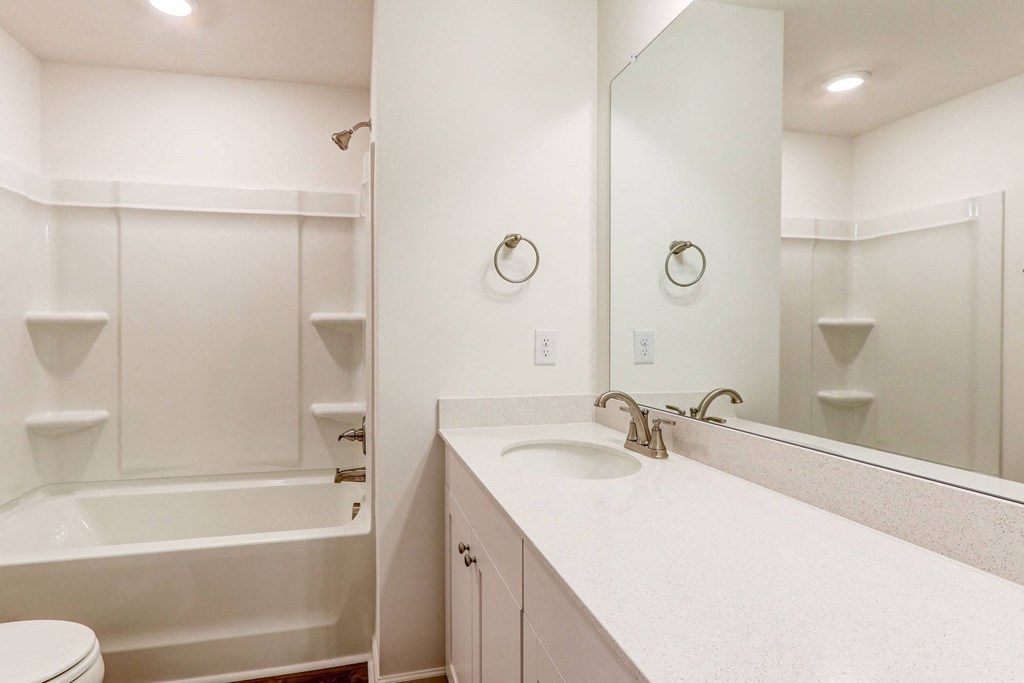 a bathroom with a sink and a tub and a mirror