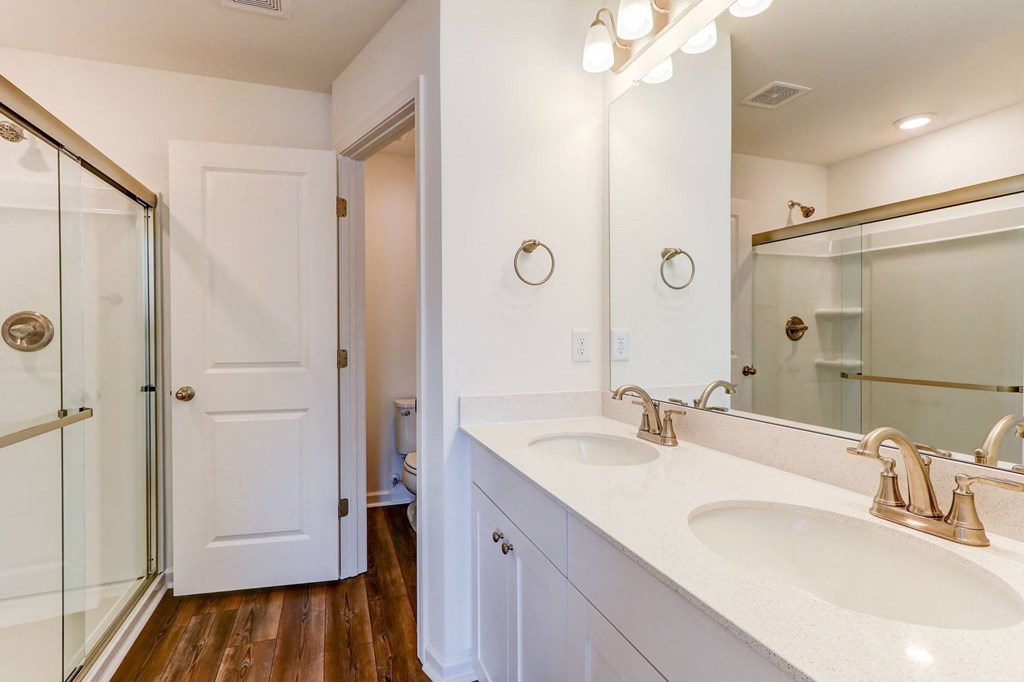 a bathroom with two sinks and a shower