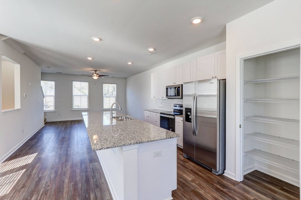 a kitchen with a granite counter top and a stainless steel refrigerator