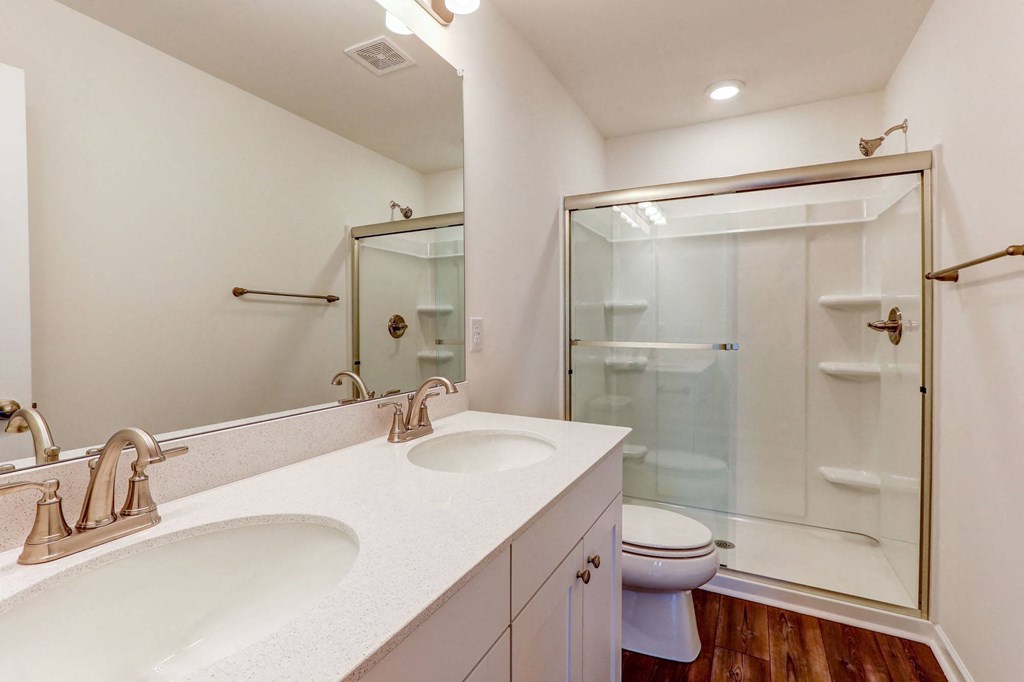 a bathroom with two sinks and a shower and a toilet