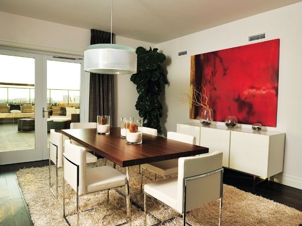 A modern dining room with a wooden table and white chairs.
