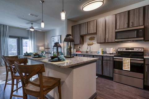 a kitchen with a large island and a counter with chairs