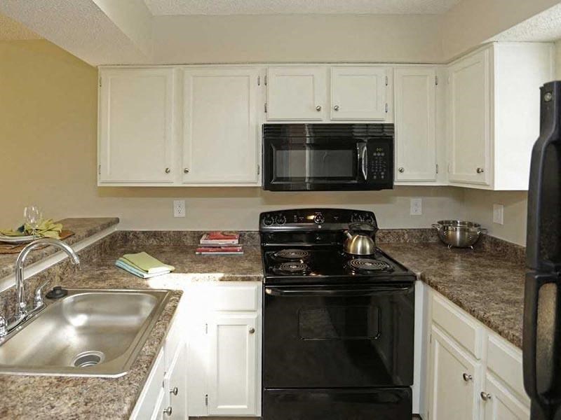 a kitchen with a black stove top oven next to a sink