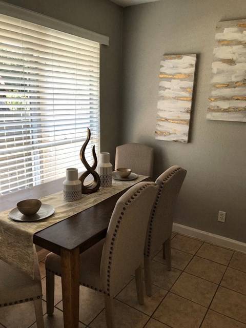 A dining room with a table and chairs.