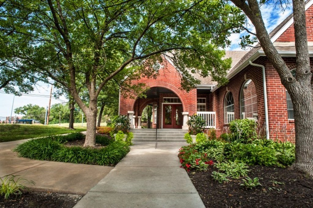 a brick building with trees in front of it