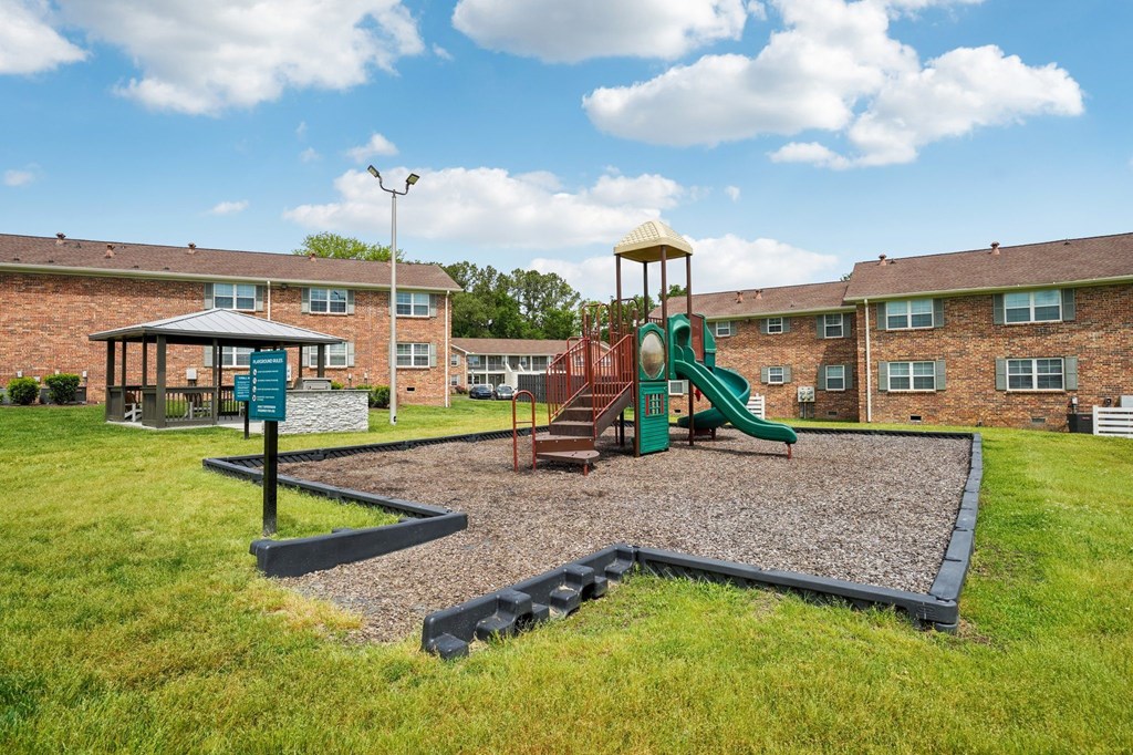 Apartment complex playground with slide, gazebo, and grill area.