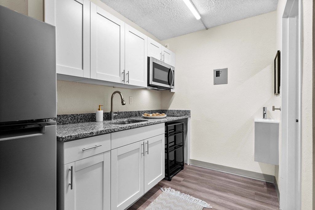 a kitchen with white cabinets and a sink and a microwave