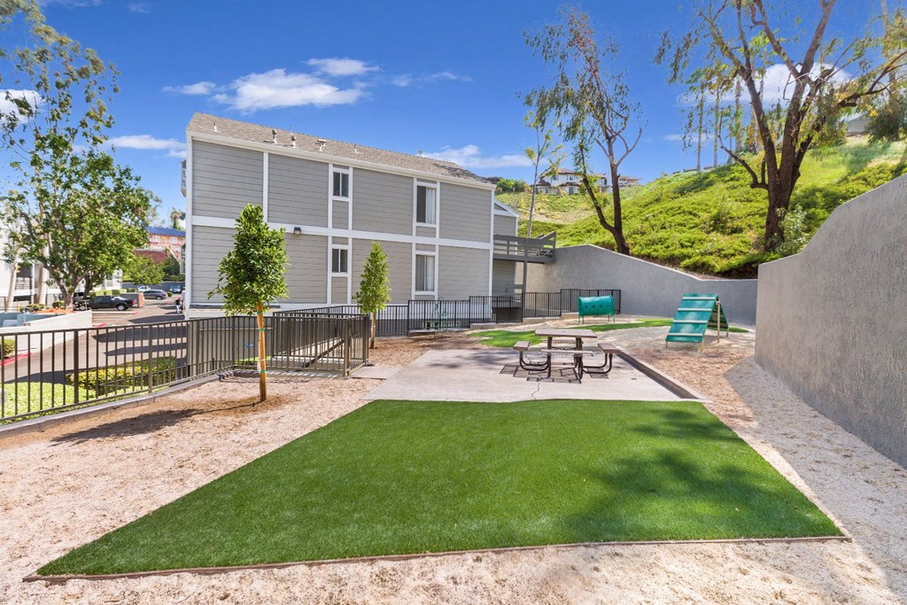 a patio with a table and chairs in front of a house