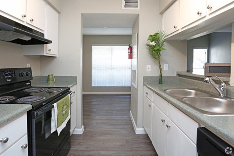 A kitchen with a black stove top oven and white cabinets.