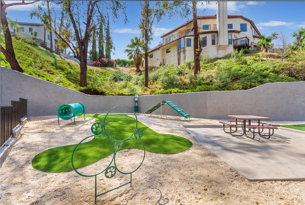 a playground and picnic table in a park next to a house