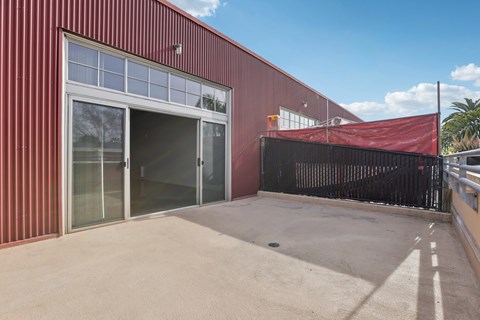 A red building with a black gate and a red tarp on top.