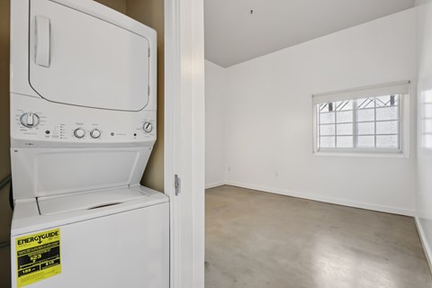 A white oven with a sticker on it is in a room with a window.